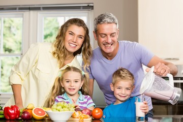 Obraz na płótnie Canvas Happy family preparing healthy smoothie