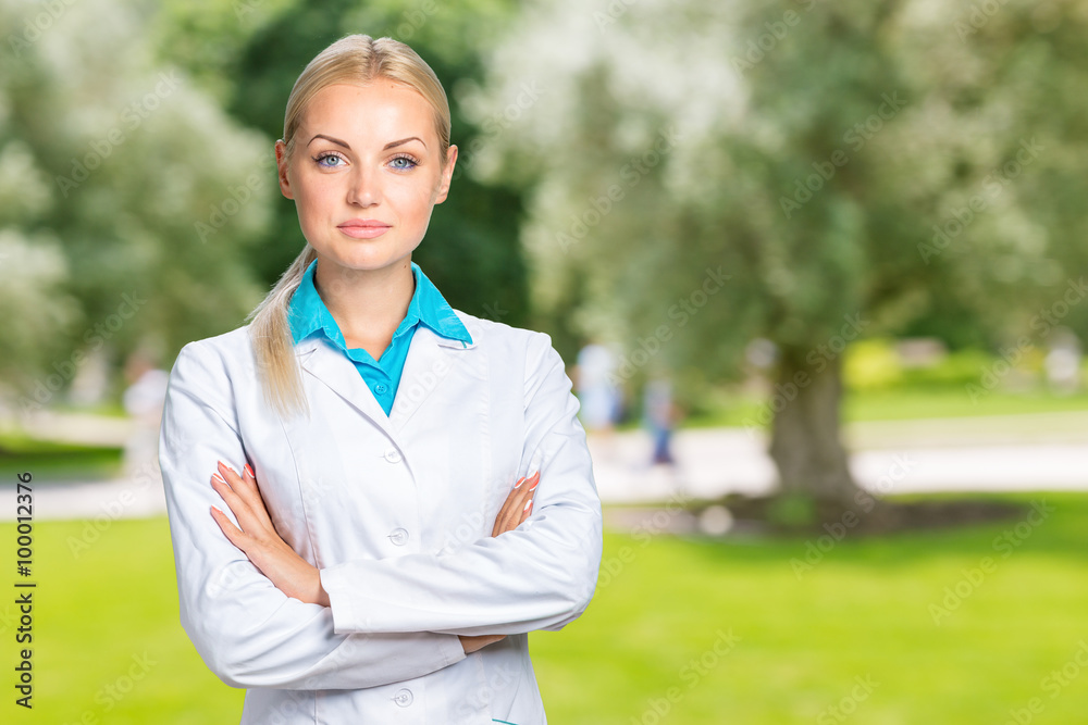 Wall mural Beautiful smiling doctor woman in medical gown