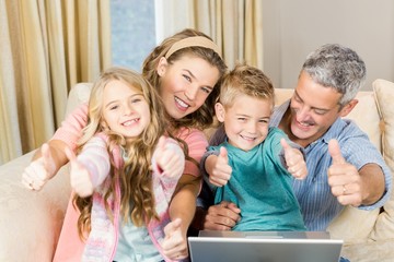 Happy family using laptop with thumbs up