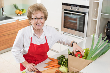 Hausfrau beim auspacken von Gemüse aus einer Einkaufstasche