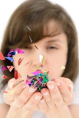Young woman blows confetti with palms