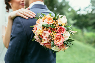 Bride holding wedding bouquet and hug groom on wedding ceremony - 100021777