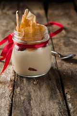 Delicious cake in jar on rustic wooden table