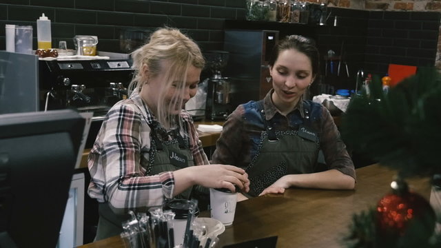Two girls at the bar. Served coffee. Slow motion.
