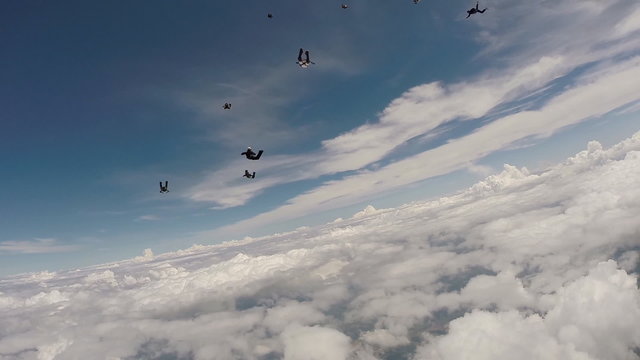 Sky diving group jumping from the plane above the clouds.
