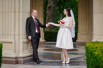 happy bride and groom walking in a summer park