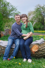Naklejka na ściany i meble husband and his pregnant wife sitting on a wooden deck