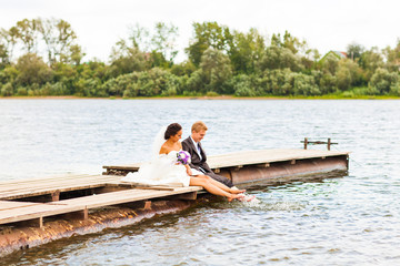 Fototapeta na wymiar wedding couple on the pier near big lake