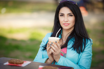 Beautiful middle age woman drinking coffe in cafe  outdoor