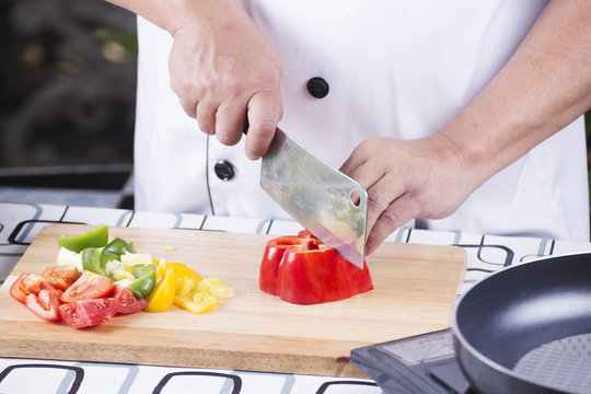 Chef cutting red bell pepper