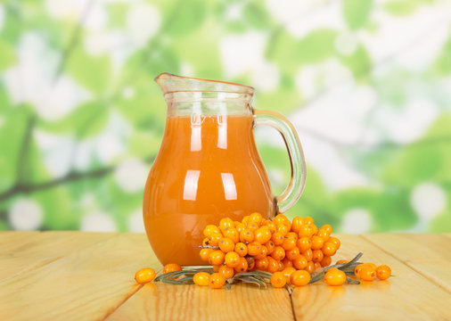 Sea Buckthorn Juice On Table And Green Background