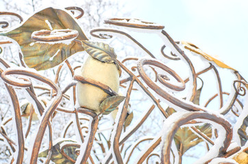 Abstract bronze sculpture under snow in park