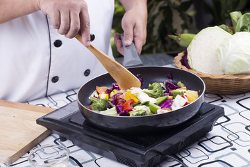 Chef cooking stir fried vegetable