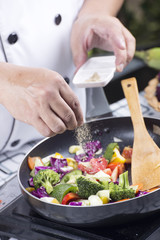 Chef putting pepper to the pan