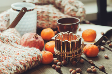 cozy winter morning at home with fruits, nuts and candles, selective focus, vintage toned
