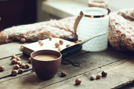 cozy morning at home, coffee and book with nuts on table, selective focus, warm toned