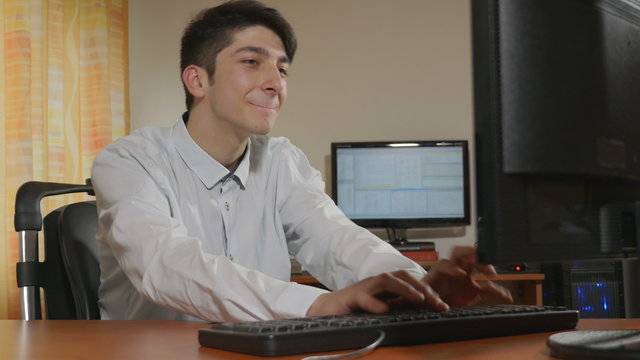 Young handsome businessman programmer dancing while working