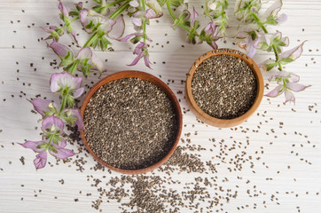 Chia seed healthy super food with flower over white wood backgro