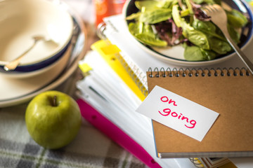 On Going; Stack of Documents. Working or Studying while Eating.