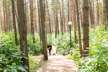 Young wedding couple walking together at park