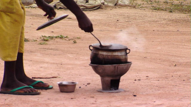 African man checking his brewing pot.