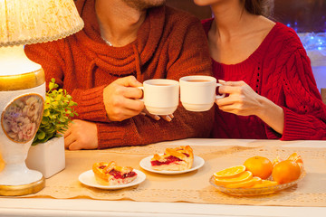 The  happy young couple with cups of tea 