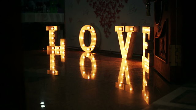 Word love consisting of lights on glossy floor 