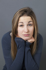 Obraz premium fatigue or boredom concept - apathetic 20s girl leaning her face on her hands to rest for winter blues, studio shot