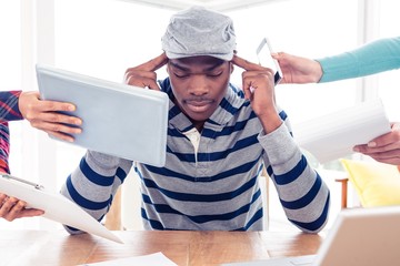 Stressed businessman by colleagues at creative office