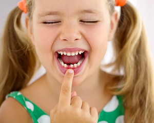 Little girl with falling tooth 