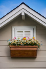 Wooden window with flower at the roof of the house.