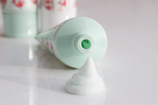 A Squirt Of Cream Next To An Opened Tube