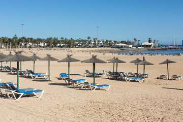 Fototapeta na wymiar Sun lounger on the beach of Caleta de Fuste, Canary Island Fuerteventura, Spain