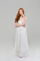 Full length portrait of a pretty redhead woman in dress