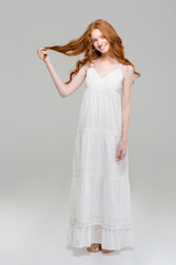 Naklejka premium Full length portrait of a happy redhead woman in dress