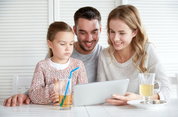 happy family with tablet pc at restaurant