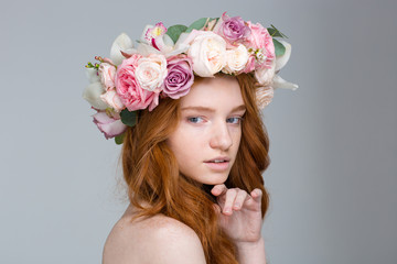 Sensual pretty redhead female with long hair in flover wreath