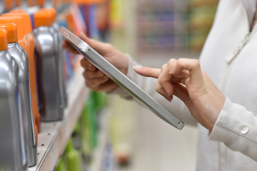 Merchandiser checking products available with digital tablet
