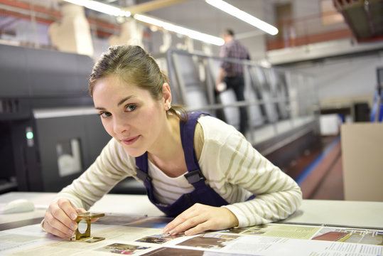 Woman working in print shop, checking document