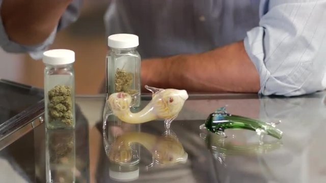 Close up of an associate in a retail marijuana shop showing products to customers