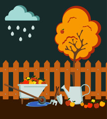 Obraz premium Autumn time garden flat style composition with a brown fence, metal watering can, an apple tree with red fruits, garden tools and a wheelbarrow with apple harvest ; dark sky, rainy.