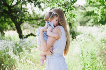 Obraz premium Young mother playing with her little daughter on the nature, motherhood, tenderness, childhood, tenderness, lifestyle