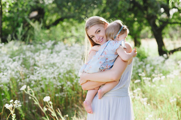 Young mother playing with her little daughter on the nature, motherhood, tenderness, childhood, tenderness, lifestyle