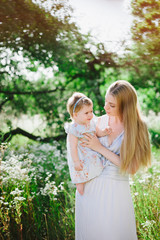 Fototapeta premium Young mother playing with her little daughter on the nature, motherhood, tenderness, childhood, tenderness, lifestyle