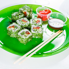 Still meatless vegetable sushi on a green plate with chopsticks,