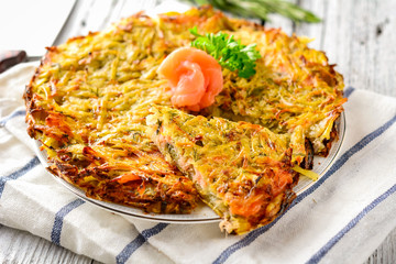 Potato pie (big potato latkes) with salmon garnished with parsley