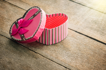 Heart shaped Valentines Day gift box on old vintage wooden plate