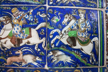 Riders on horseback during the hunt on the vintage ceramic tiles of the 19th century