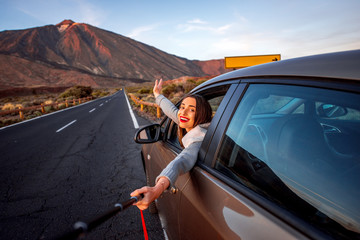 Woman in car with volcano on background