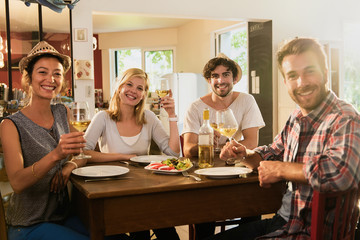 In a warm house, two couples of friends having fun during a lunch 